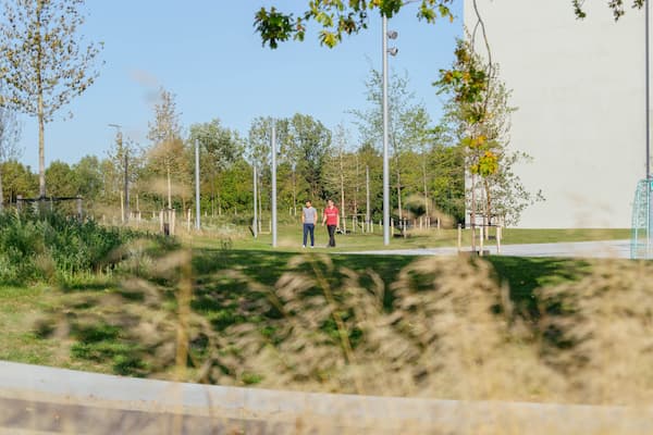 2 people taking a walk around a green campus